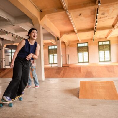 Osoba jeżdżąca na deskorolce w skateparku zbudowanym z materiałów takich jak sklejki specjalistyczne.