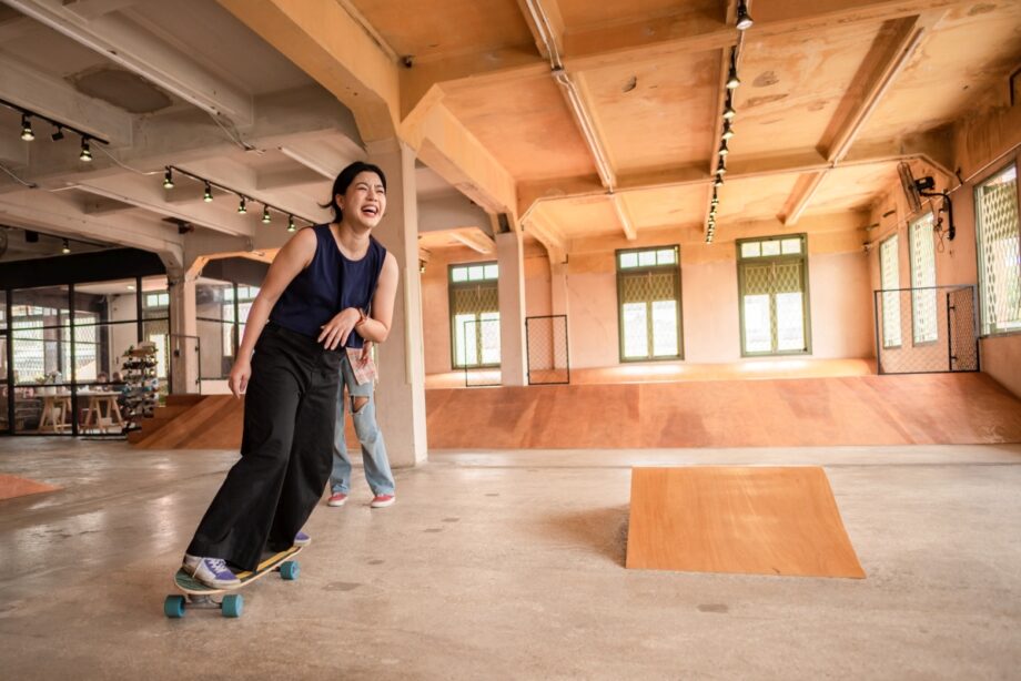 Osoba jeżdżąca na deskorolce w skateparku zbudowanym z materiałów takich jak sklejki specjalistyczne.